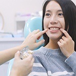 dentist helping patient with dental implant