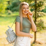 Blonde woman walking in nature and putting in Invisalign