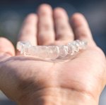 Close-up of open palm holding Invisalign aligner