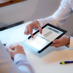 Showing patient a dental insurance form on a tablet